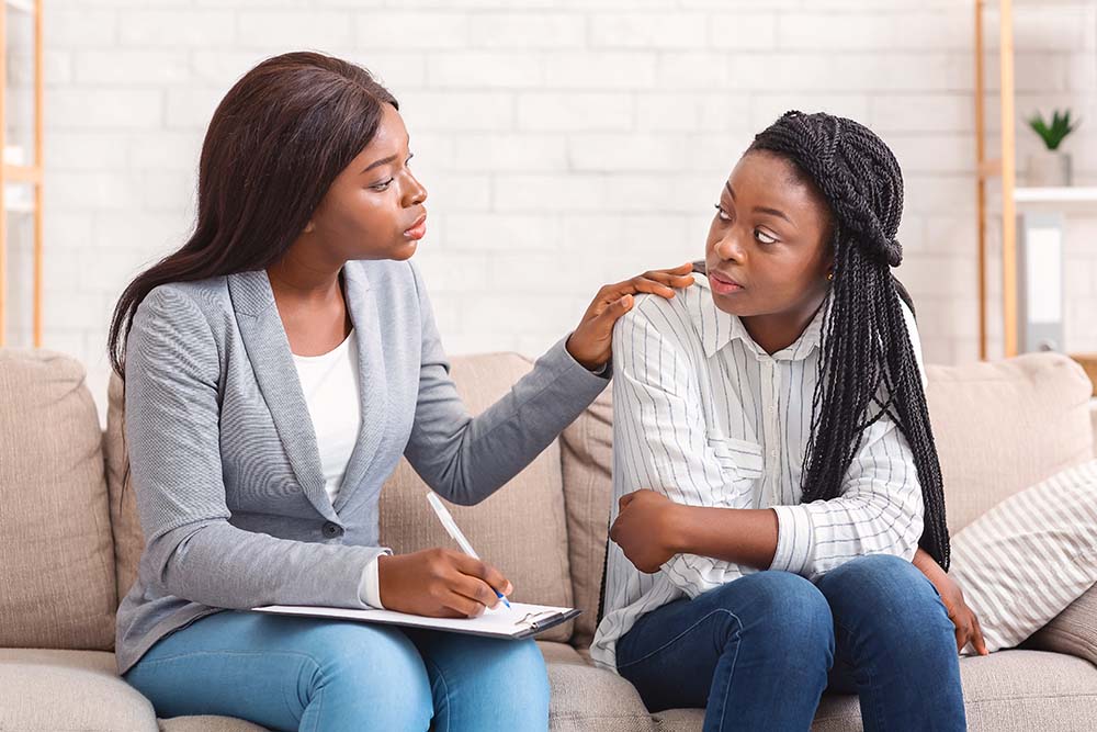 Black female counselor in a supportive session with a young person